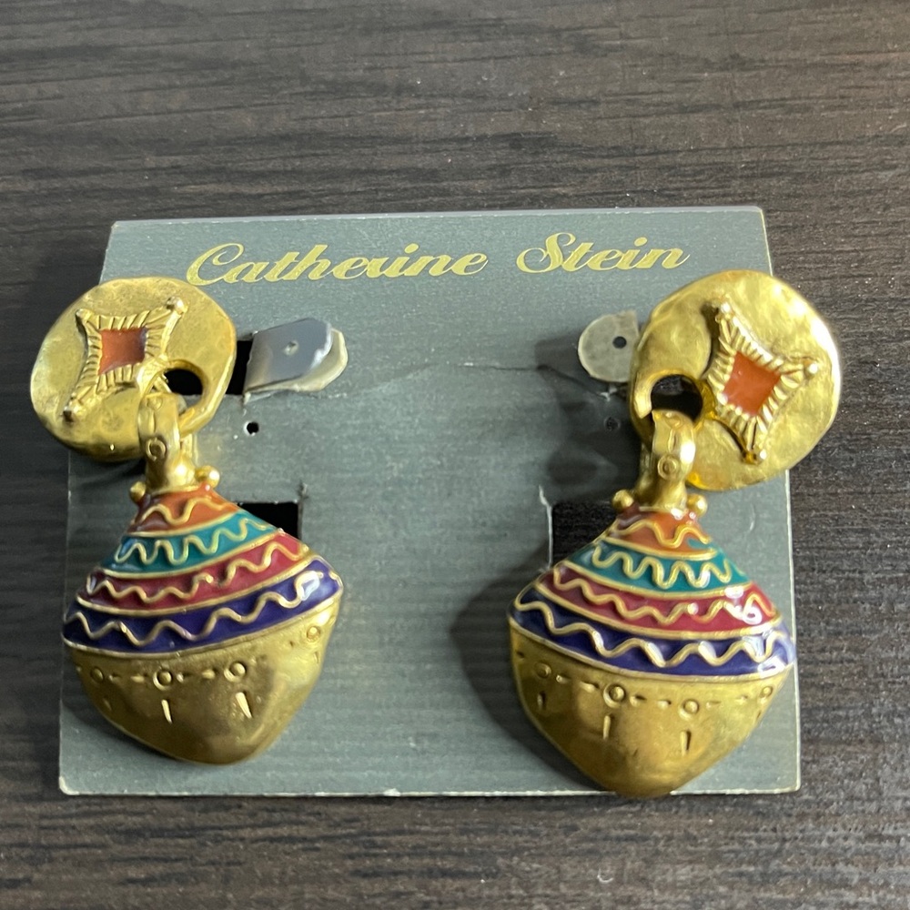 Catherine Stein and feature a gold-toned jhumka drop design intricate etched